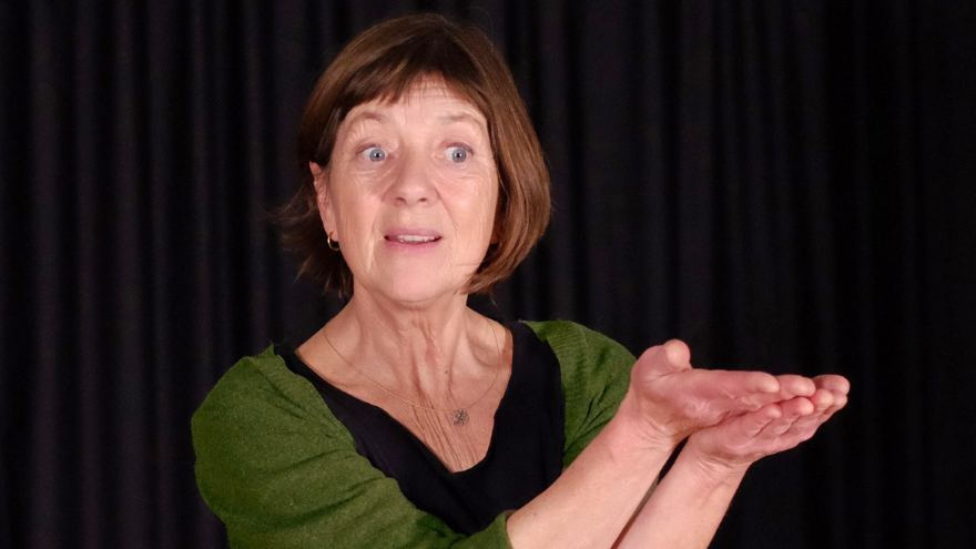storyteller Suse Weisse holding hands up whilst storytelling